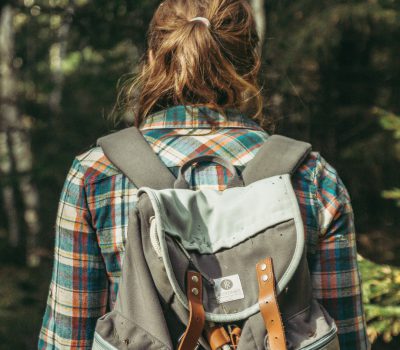 Frau mit Rucksack im Wald.